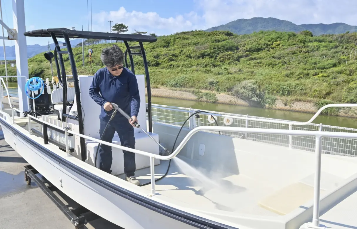 男性が船を洗浄している